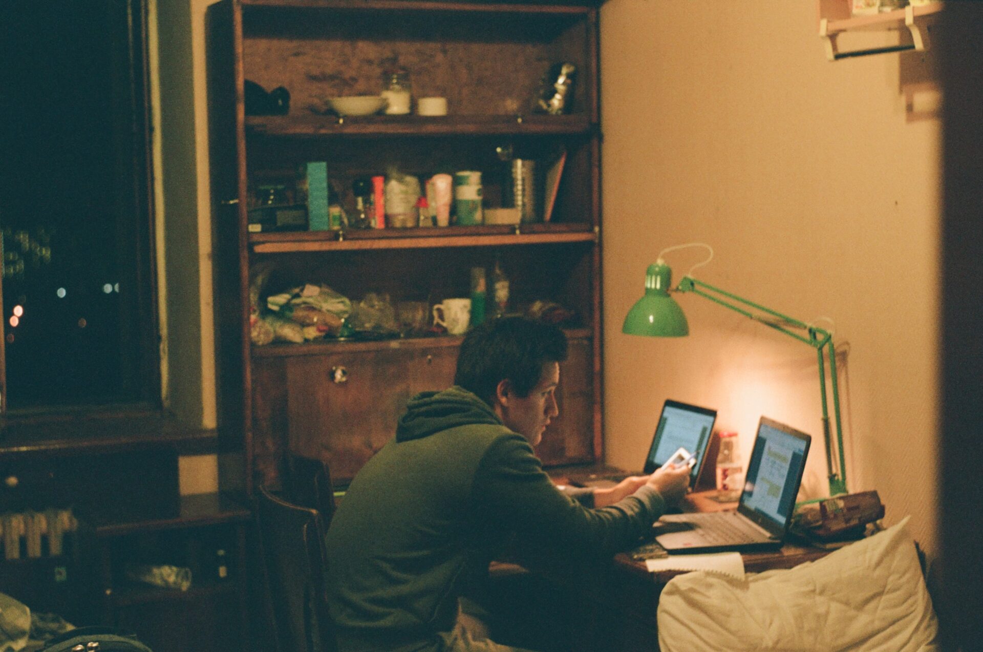 man sitting at a dimly lit desk studying