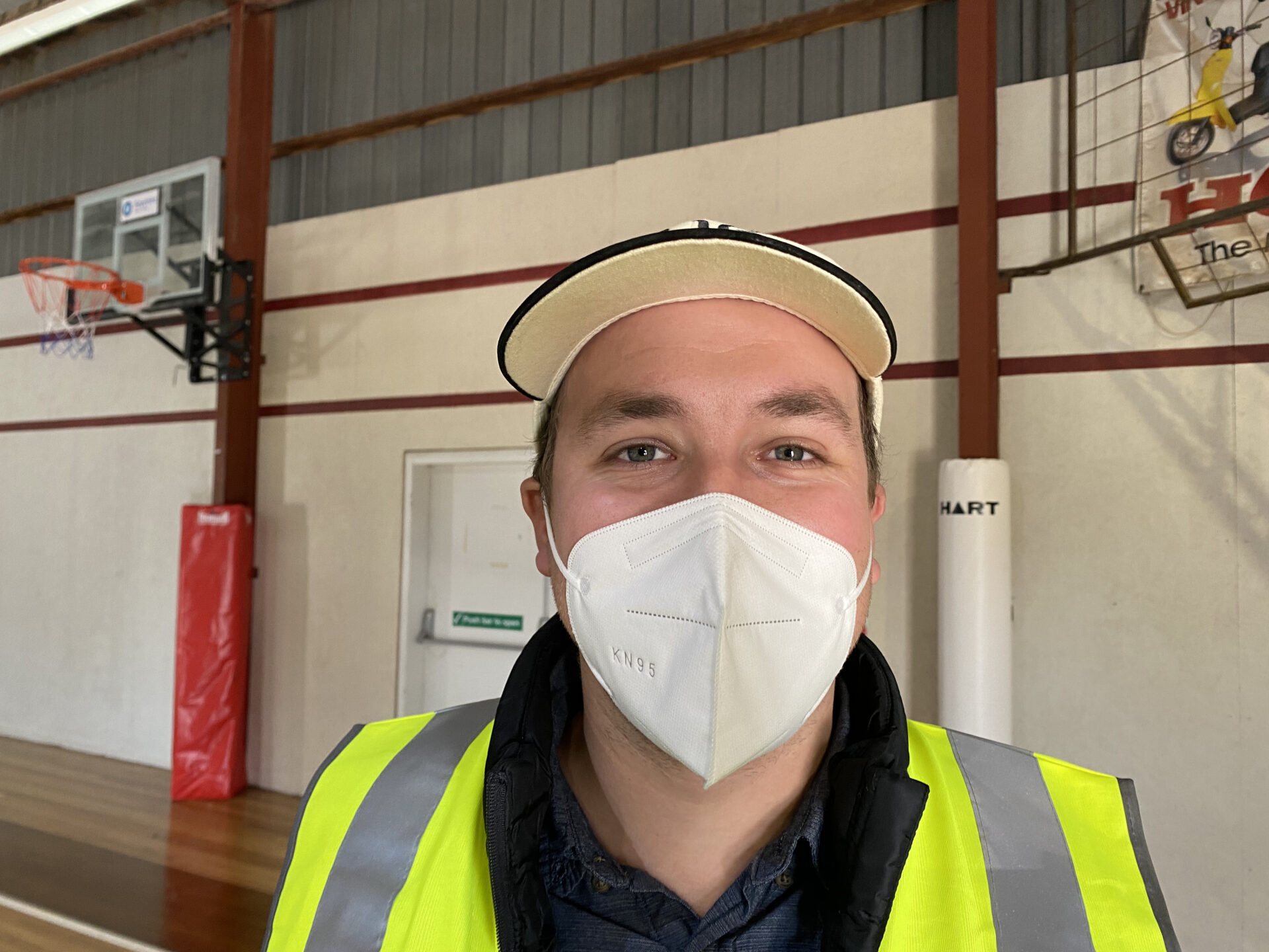 Chris folder wear a high-vis vest with a mask on presumably smiling at the camera