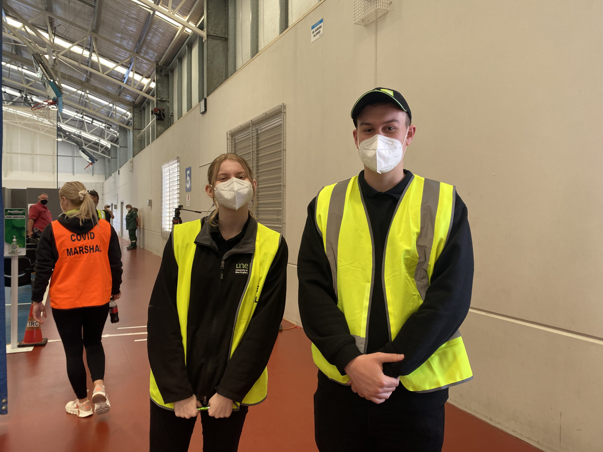 UNE Life members stand in high-vis vests as covid marshals at COVID Clinic event