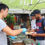 A&W Free Student BBQ, man plating food on another mans plate 