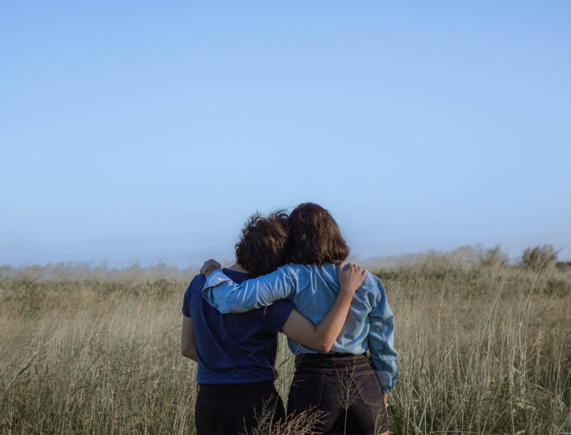 two people embracing in a half hug looking at the sky