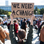 Rear,View,Of,People,With,Placards,And,Posters,On,Global 